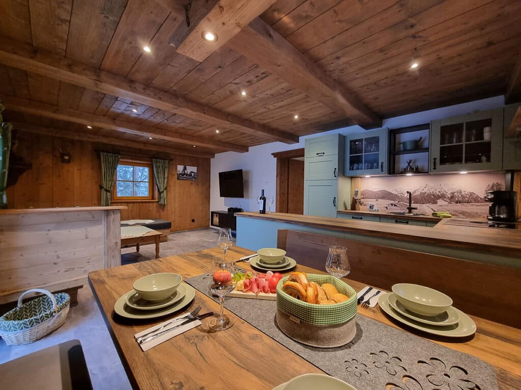 Gedeckter Esstisch mit Blick in den Wohnraum_Alm Chalet