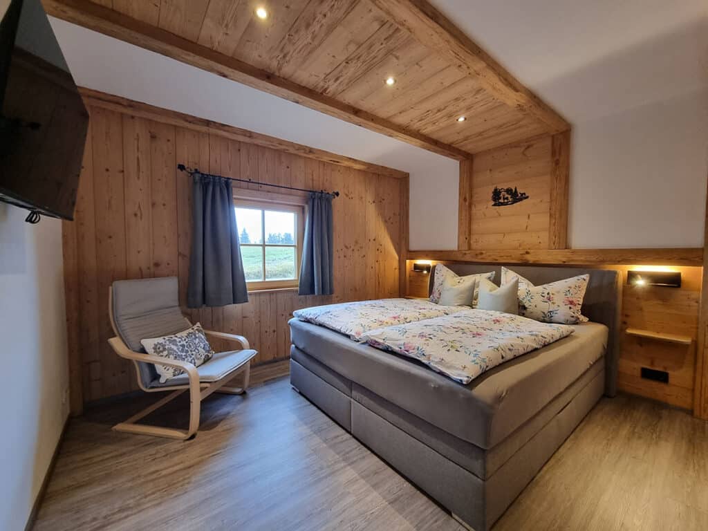 Schlafzimmer Nr.2 mit Boxspringbett und Holzverkleidung_Alm Chalet